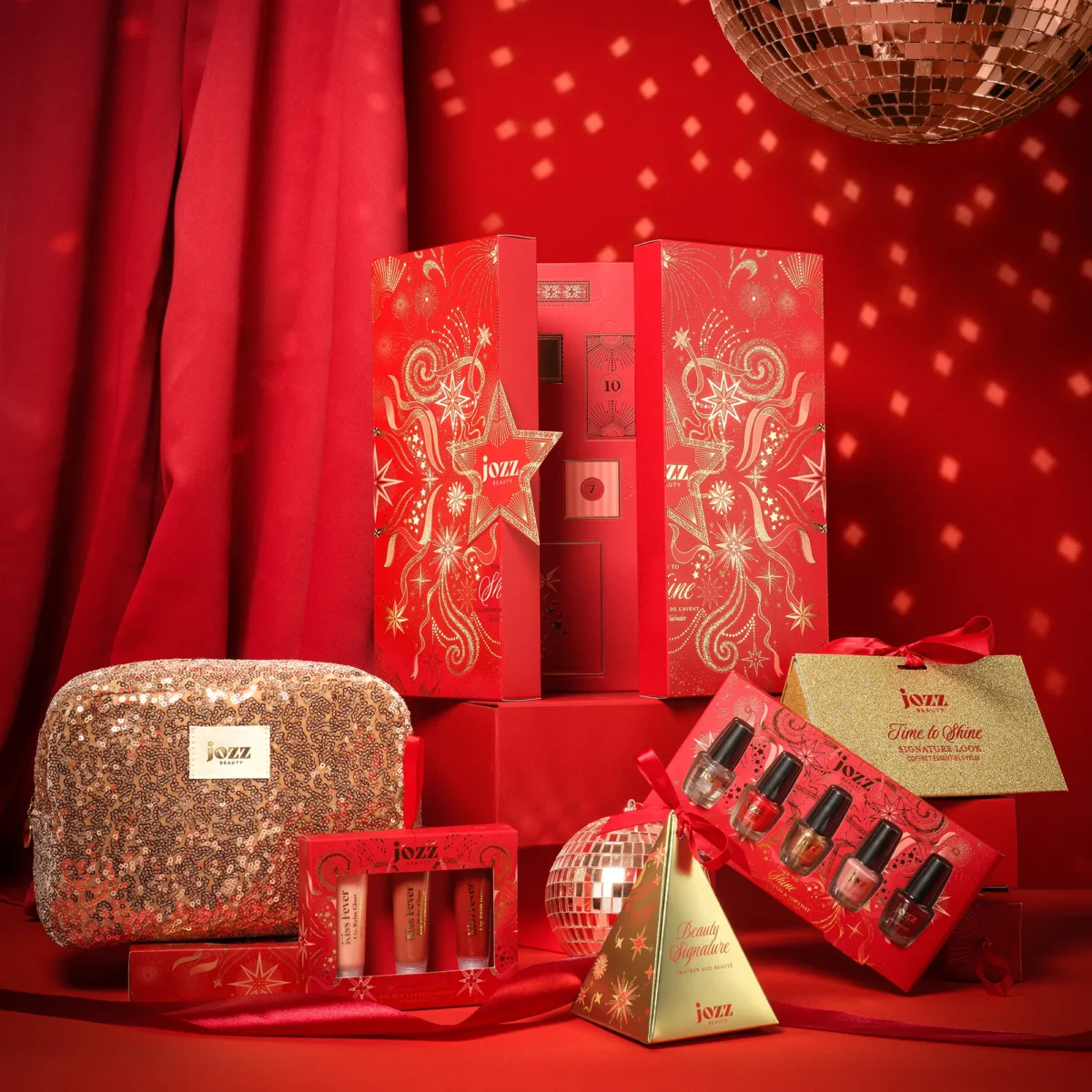 Calendrier de l’Avent Time To Shine ouvert au centre d’une scénographie de Noël rouge avec coffrets et accessoires JOZZ Beauty
