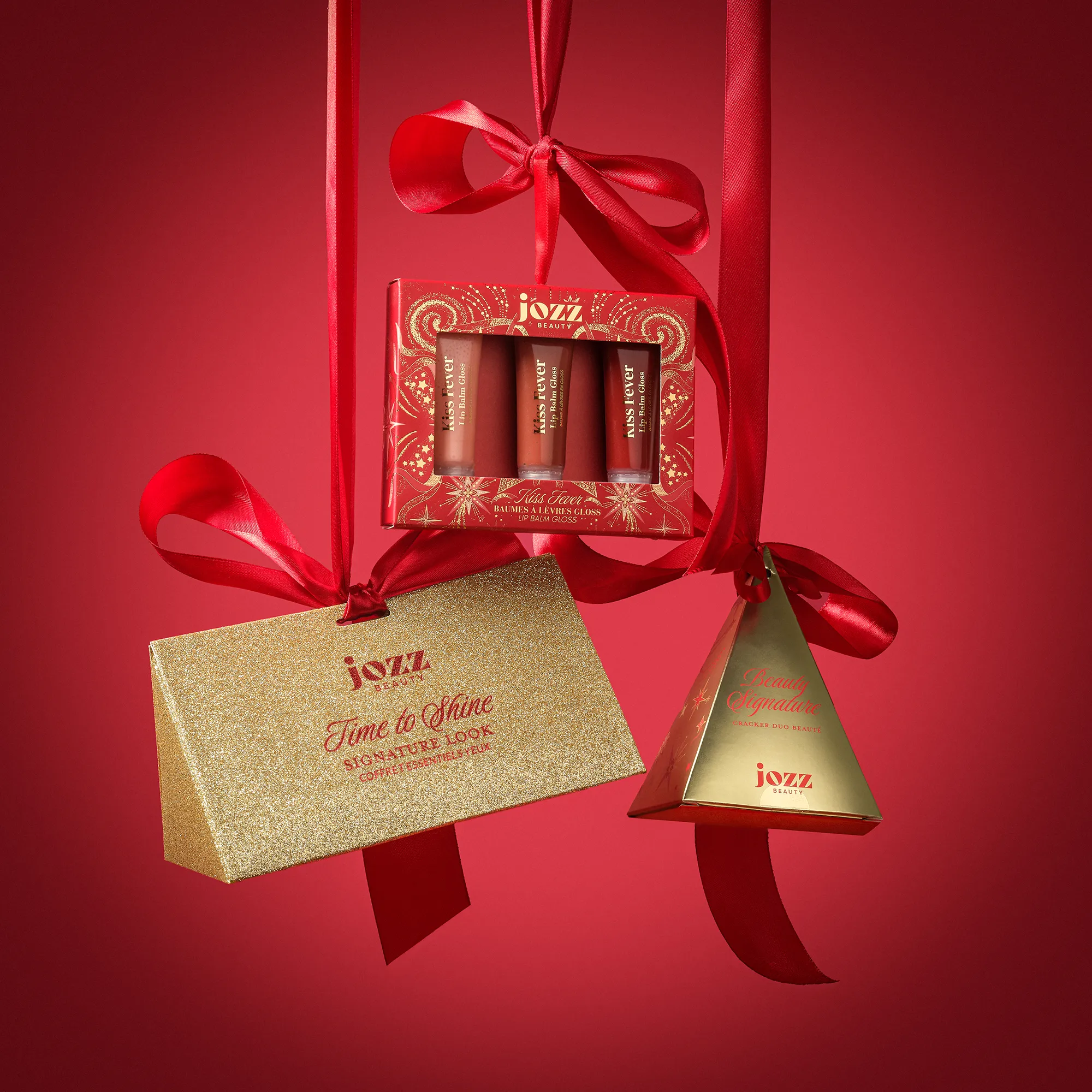 Mini Cracker Triangle doré suspendu avec des coffrets beauté JOZZ Beauty dans un décor de Noël rouge