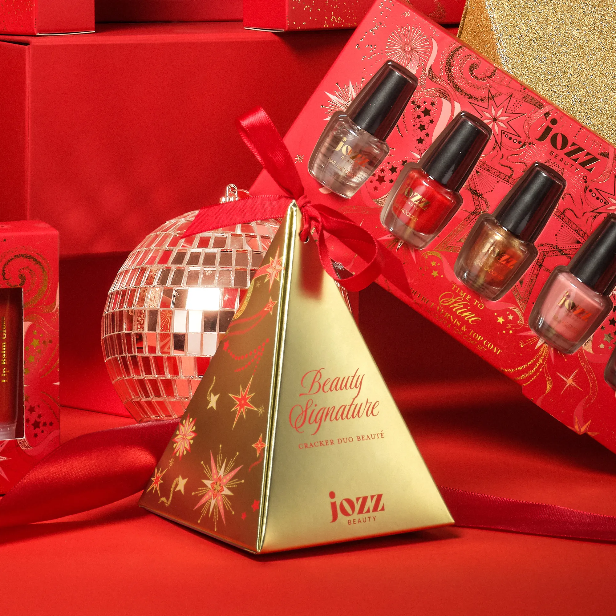 Mini Cracker Triangle doré placé devant un coffret de vernis JOZZ Beauty et une boule disco